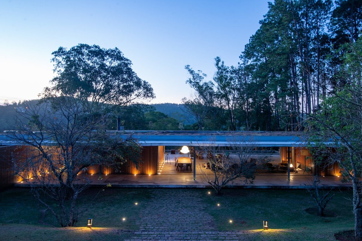 Casa de campo ao anoitecer, entre árvores